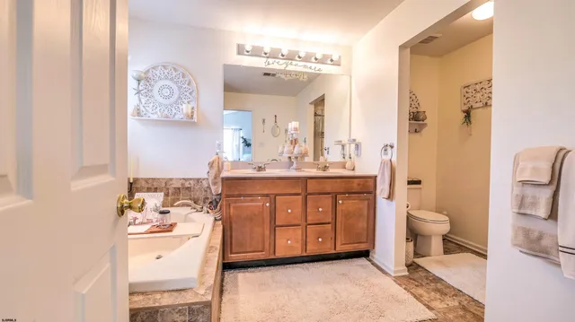 a bathroom with a double vanity sink mirror and toilet