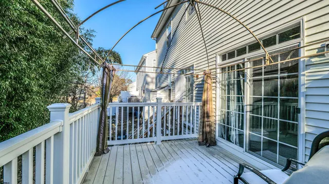 a view of a deck with wooden floor and fence and a floor