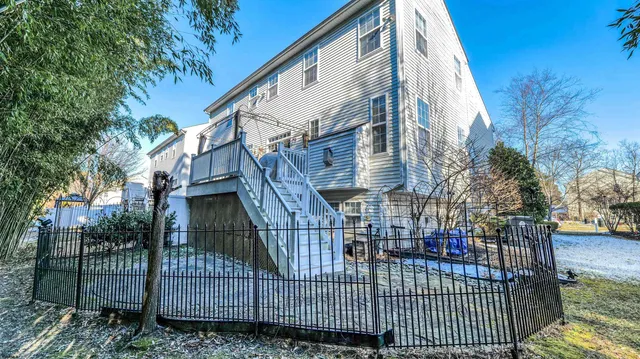 a view of a brick house with large windows and a small yard