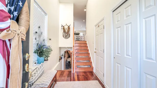a view of a hallway with wooden floor and stairs