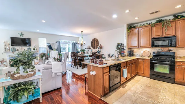 a kitchen with stainless steel appliances granite countertop a stove a sink dishwasher and a microwave oven with wooden floor