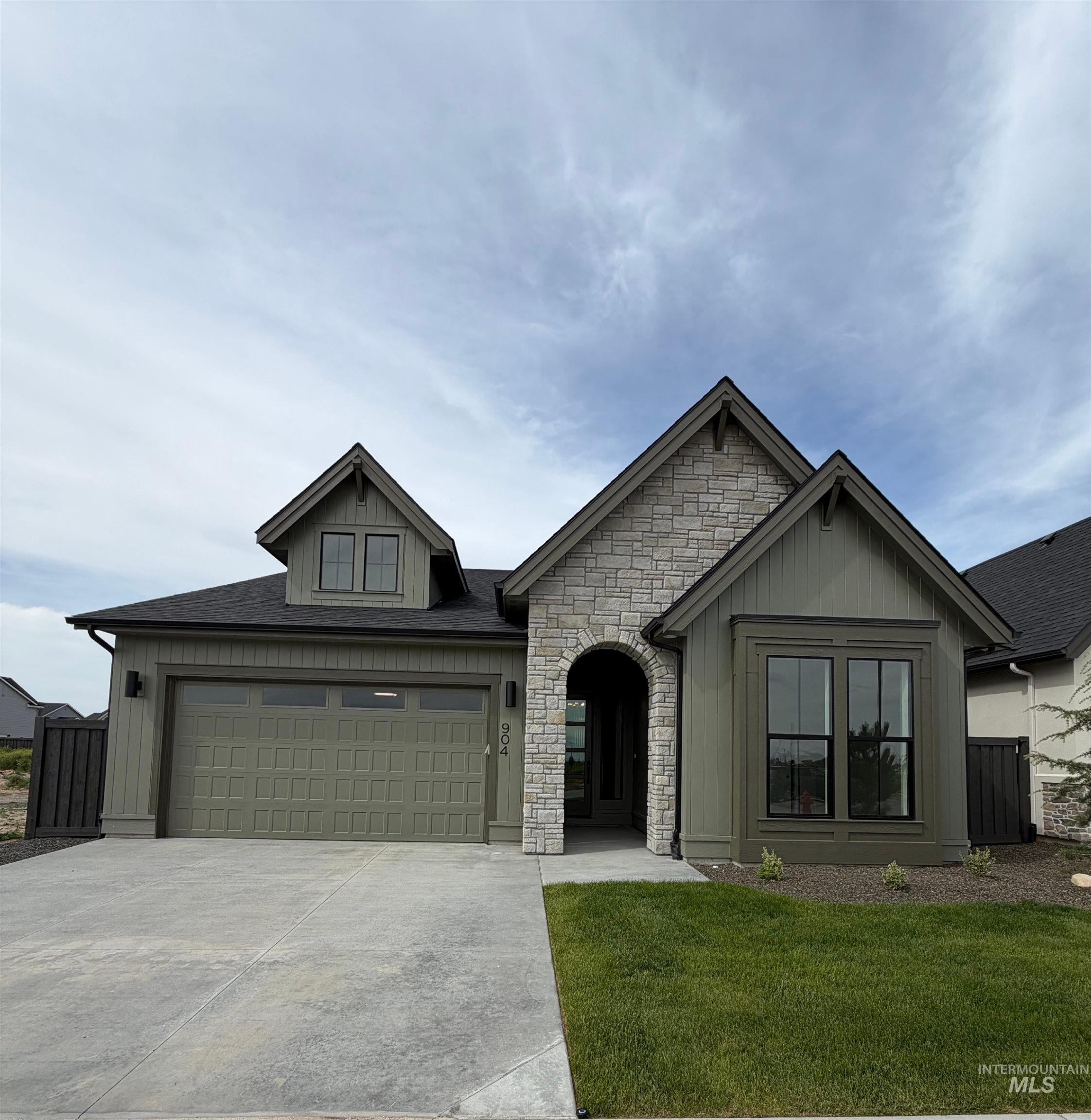 Craftsman-style exterior with a stone accent facade and olive-toned board and batten siding