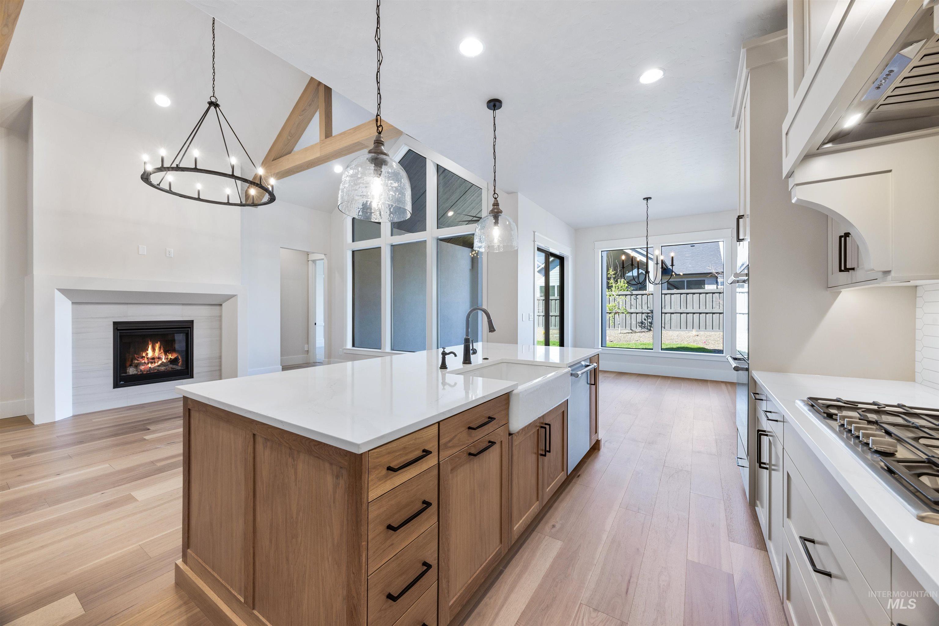 904 East Escalation Street Meridian, ID 83642 - Photo 20 of 36 Gourmet kitchen with a large center island featuring a farmhouse sink and modern pendant lighting