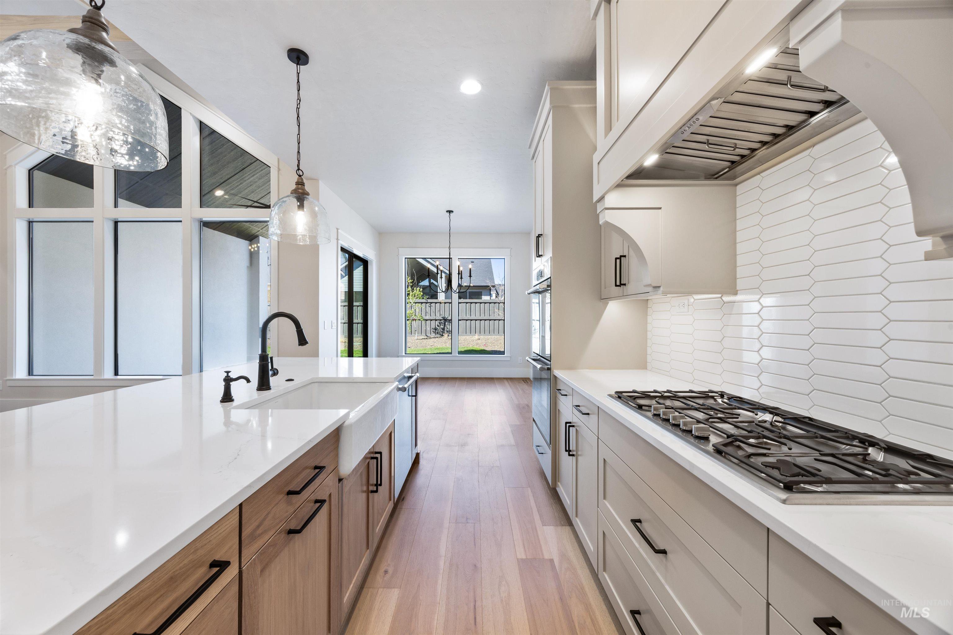 904 East Escalation Street Meridian, ID 83642 - Photo 21 of 36 Modern kitchen featuring a gas range, white quartz countertops, and light wood-finish flooring