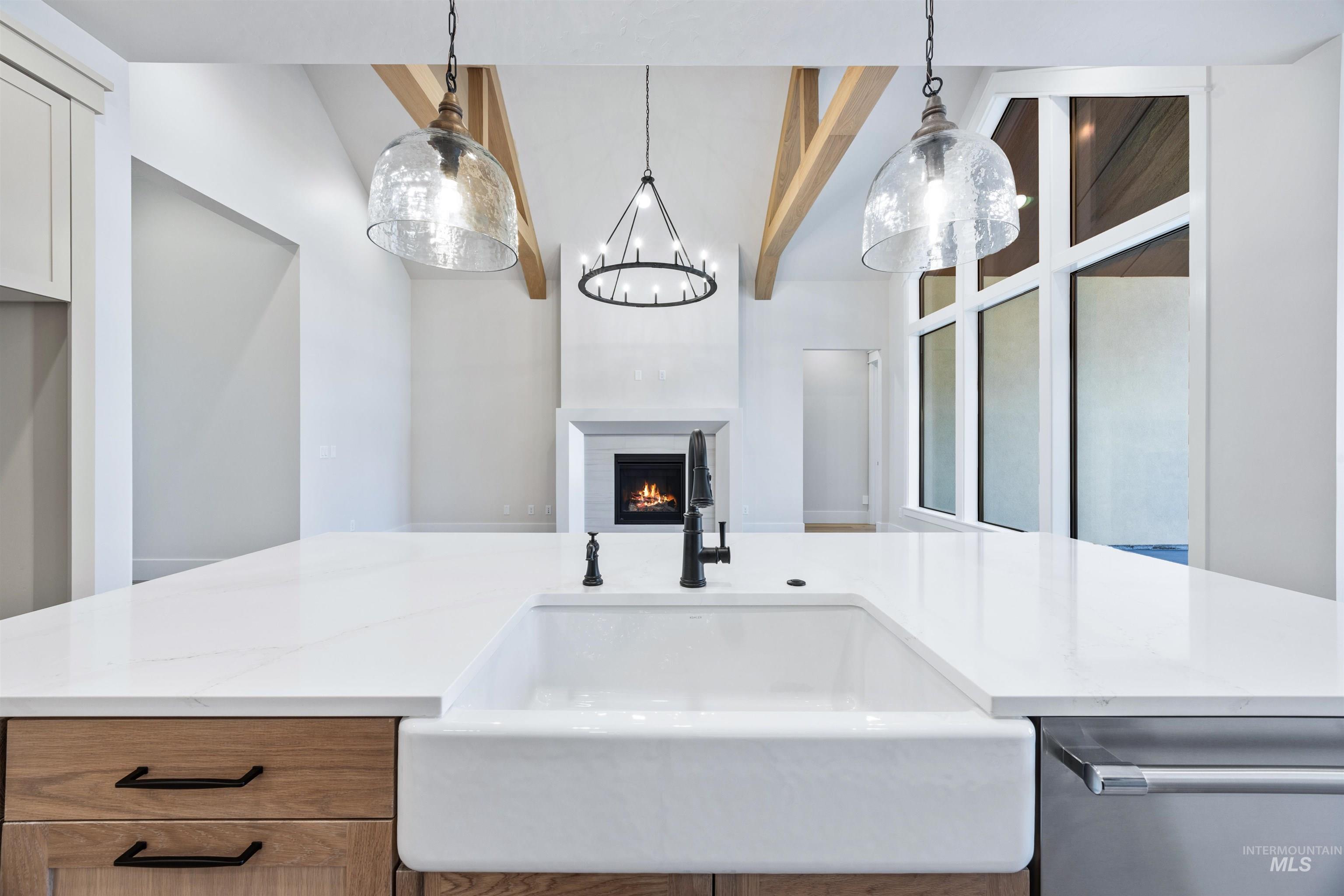 904 East Escalation Street Meridian, ID 83642 - Photo 22 of 36 Kitchen island with a white farmhouse sink, matte black faucet, and white countertop