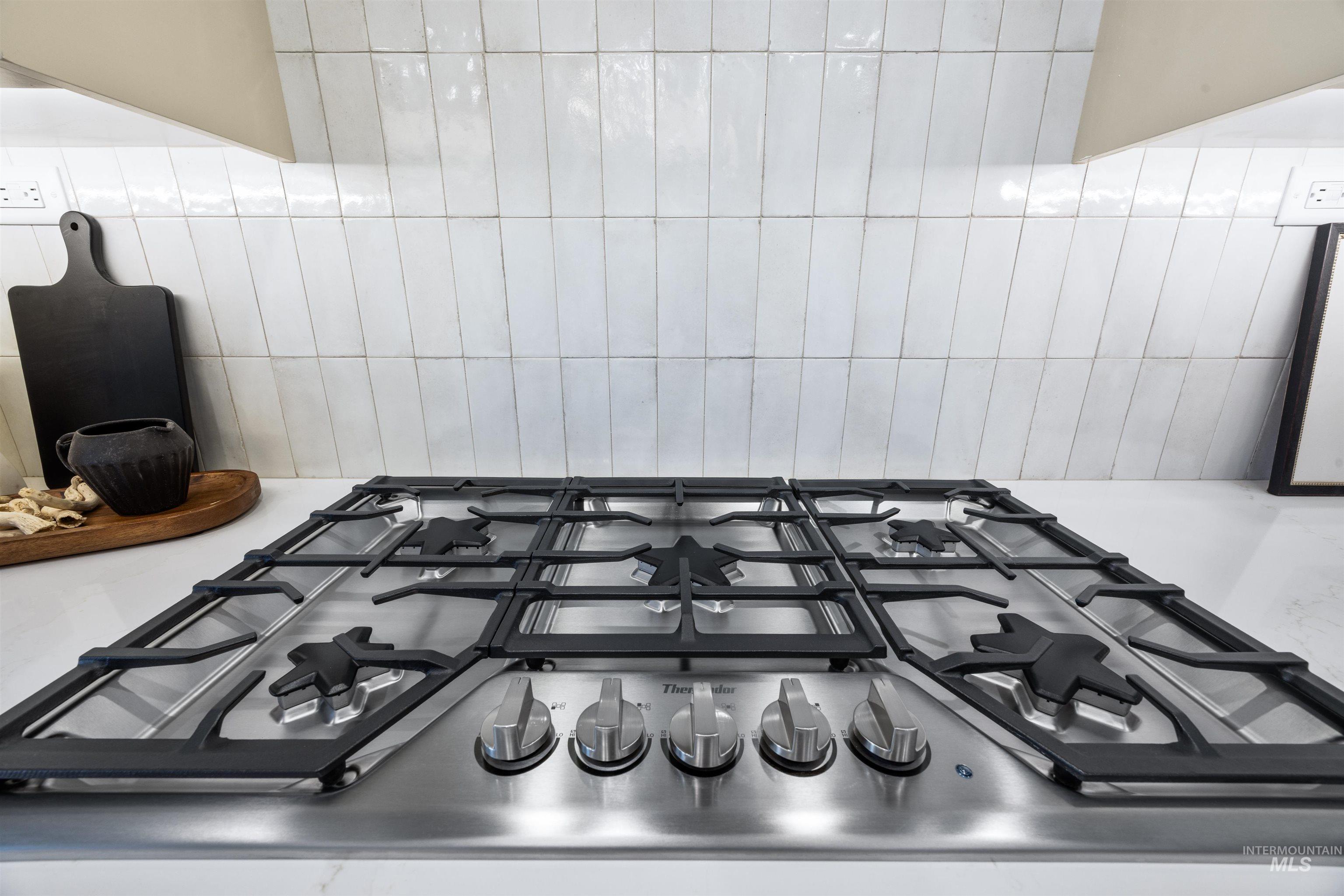 904 East Escalation Street Meridian, ID 83642 - Photo 24 of 36 Stainless steel gas cooktop with five burners set into a white countertop, complemented by a white subway tile backsplash