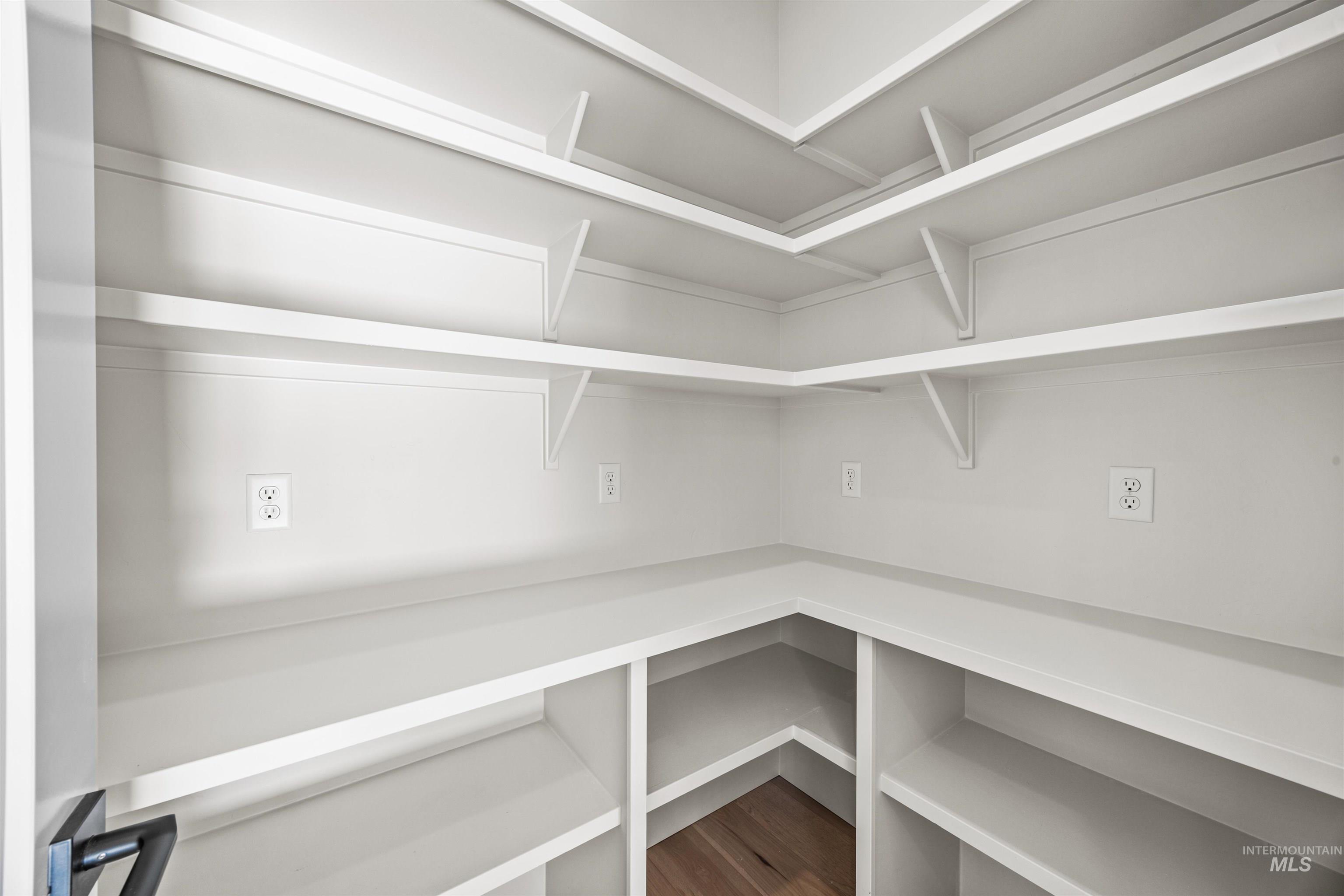 904 East Escalation Street Meridian, ID 83642 - Photo 26 of 36 Built-in pantry shelving featuring ample storage, integrated power outlets, and wood-finish flooring