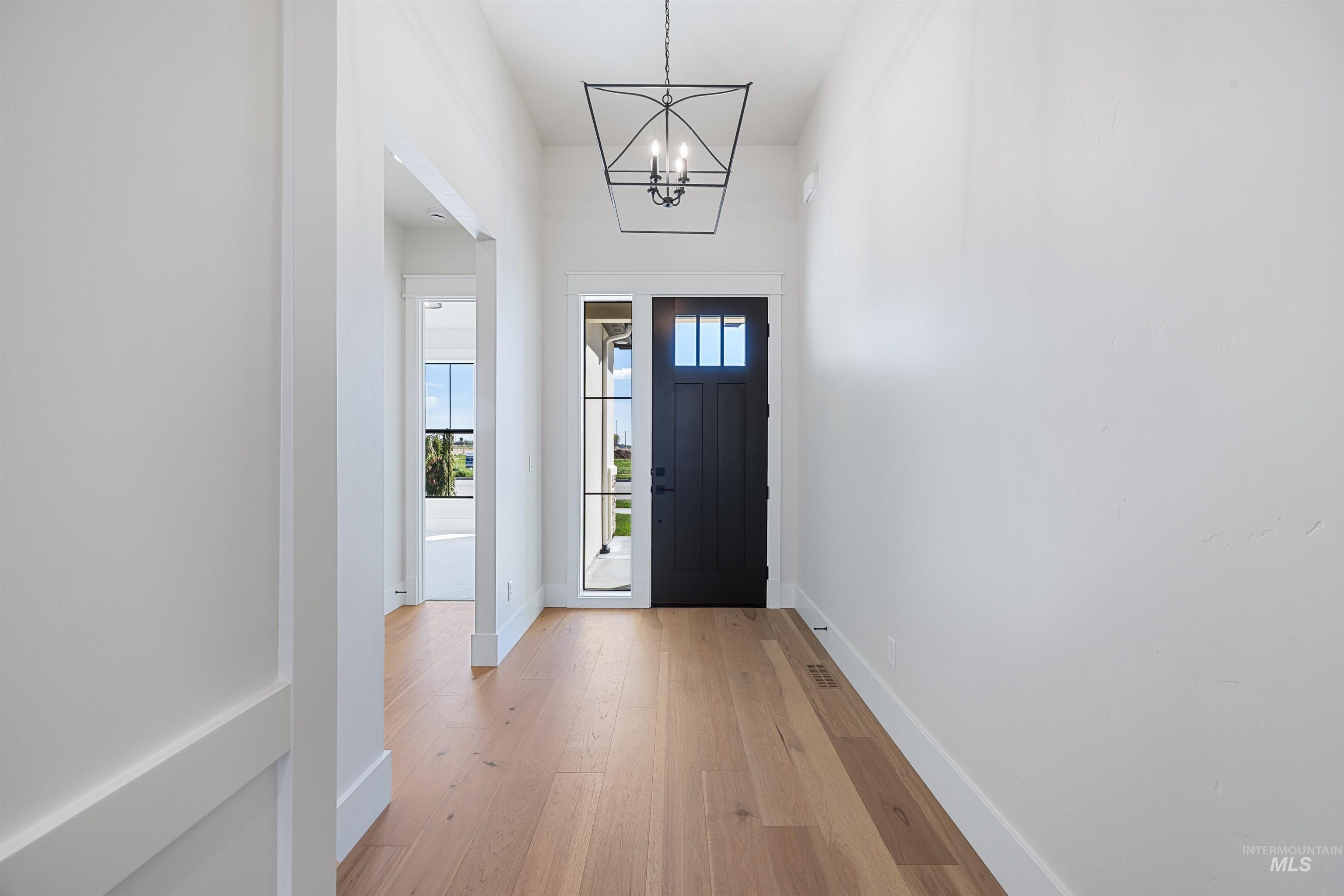 904 East Escalation Street Meridian, ID 83642 - Photo 3 of 36 Entryway featuring wood-finish flooring, white walls, and a recessed archway