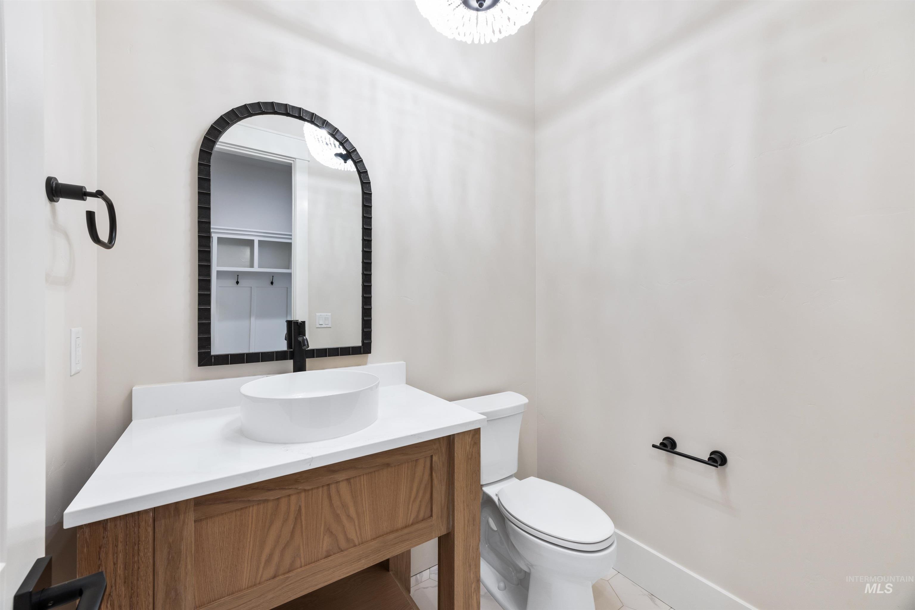 904 East Escalation Street Meridian, ID 83642 - Photo 36 of 36 Contemporary bathroom featuring a wood-finish vanity with a vessel sink, a white countertop, and matte black fixtures