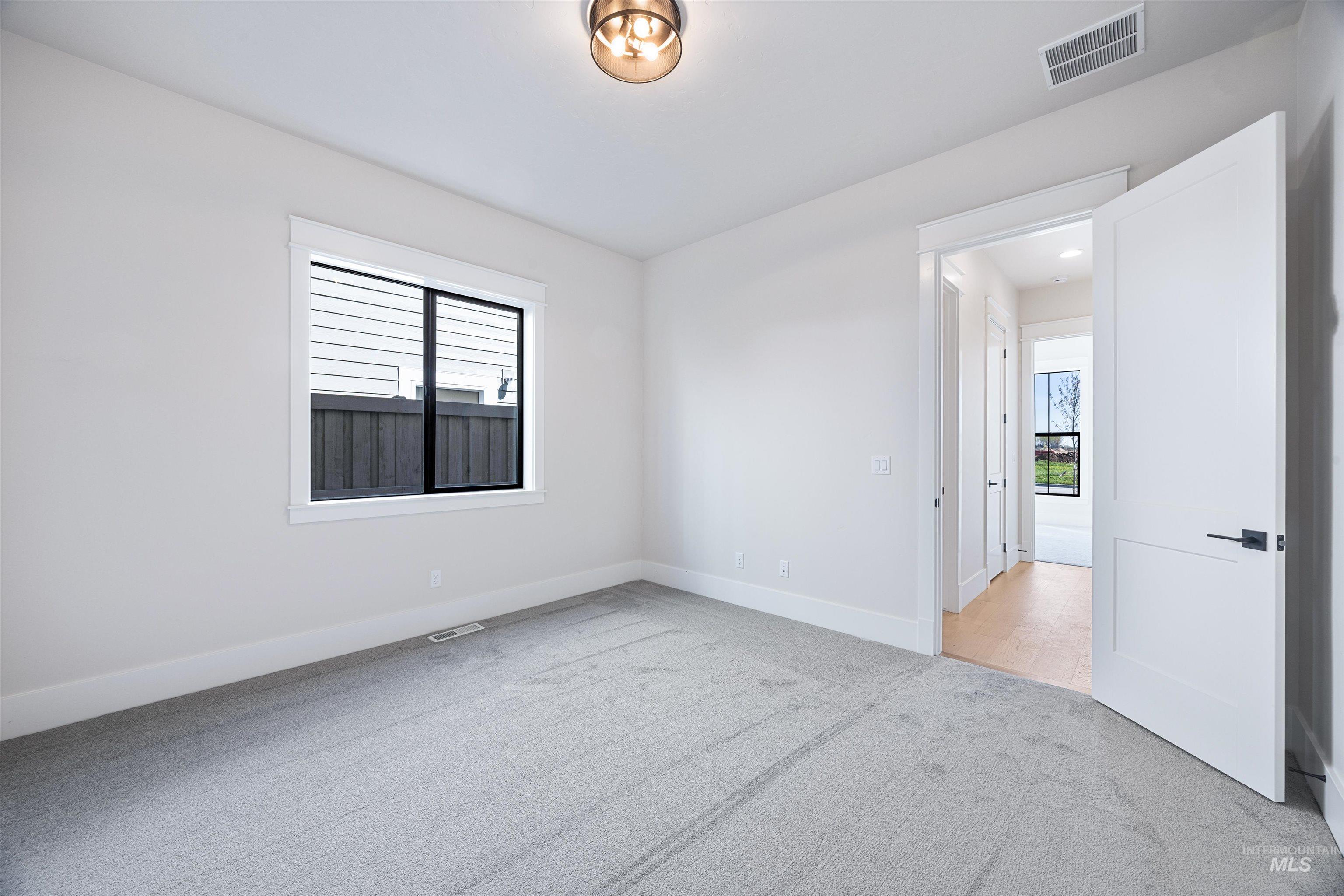 904 East Escalation Street Meridian, ID 83642 - Photo 8 of 36 Room featuring light gray carpeting, white walls, and a contemporary ceiling light fixture