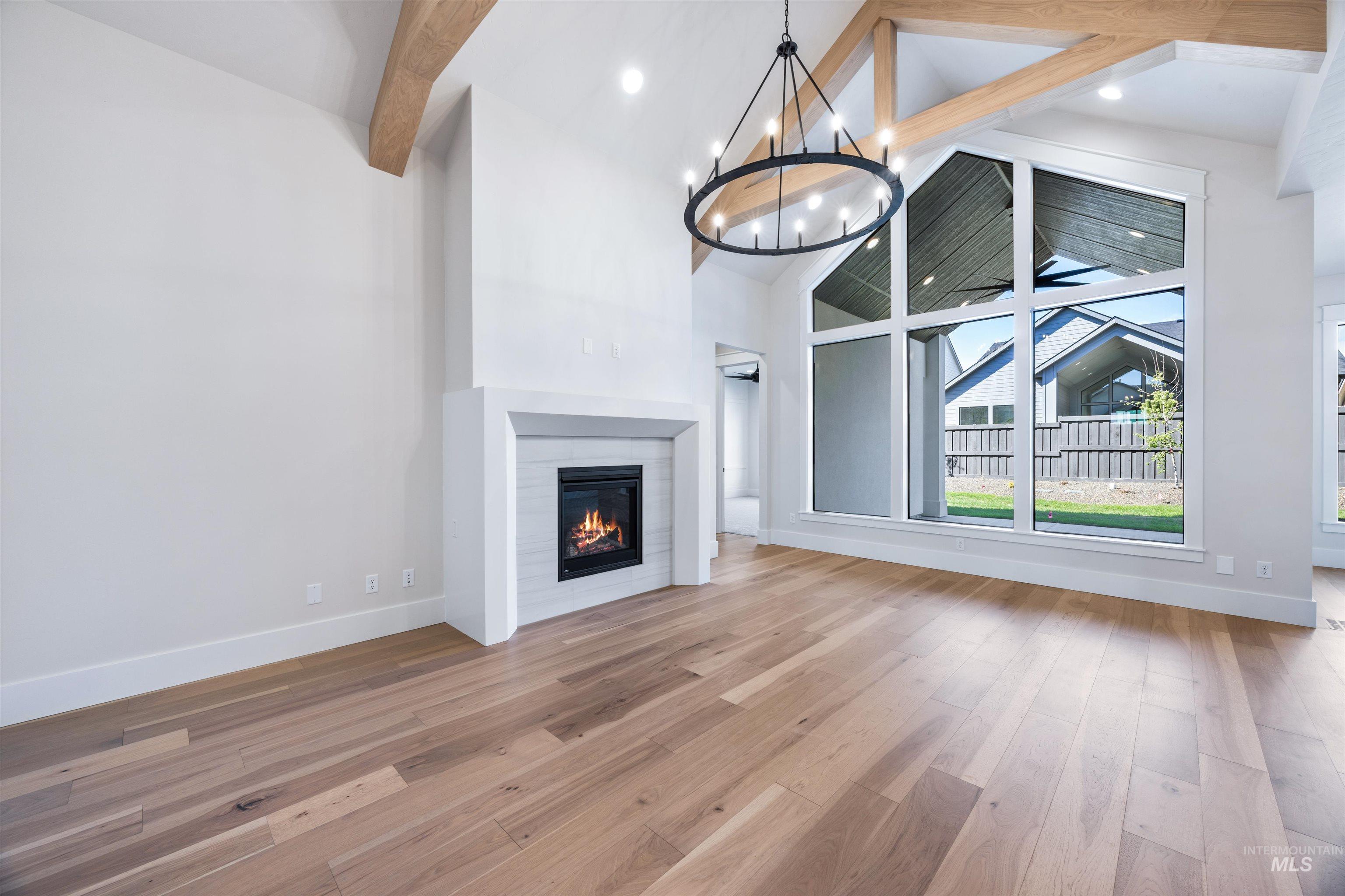 904 East Escalation Street Meridian, ID 83642 - Photo 9 of 36 Great room with soaring ceilings featuring exposed wood beams and a large circular chandelier