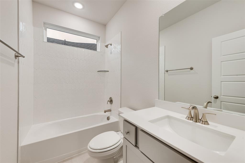 1013 Canoe Way Crowley, TX 76036 - Photo 21 of 26 a bathroom with a granite countertop sink a toilet and shower