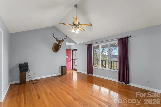 a view of a room with window ceiling fan and wooden floor
