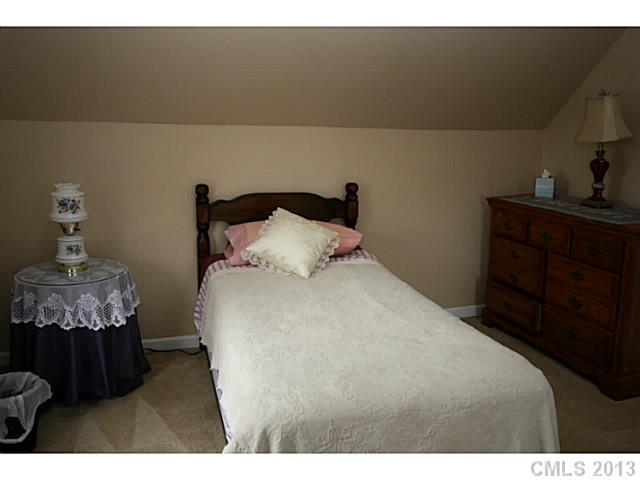 6526 Nevin Road Charlotte, NC 28262 - Photo 10 of 16 a bedroom with a bed and wooden floor