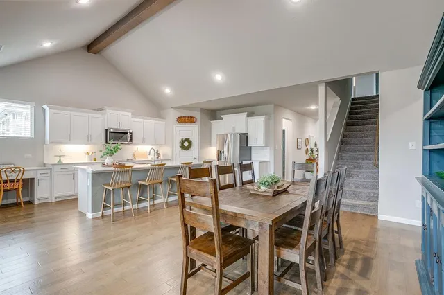 a living room with furniture kitchen view and a wooden floor