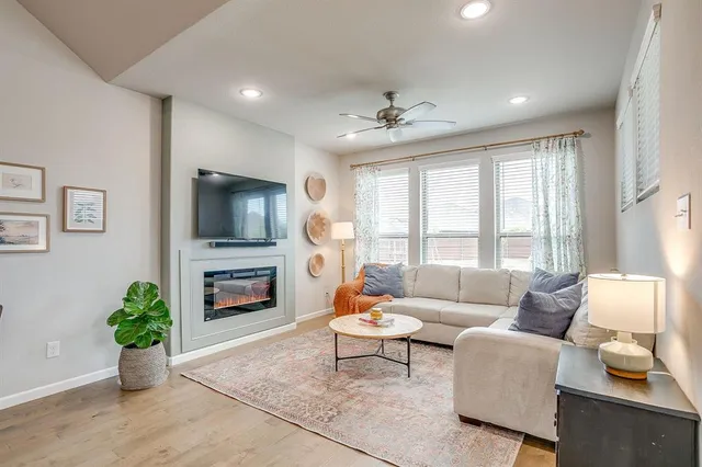 a living room with furniture a flat screen tv and a fireplace