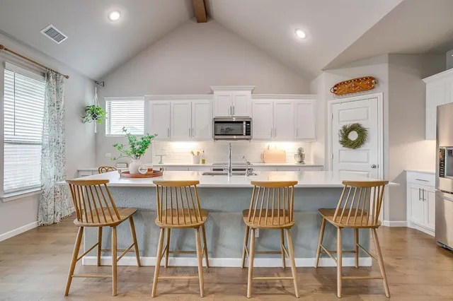 a kitchen with stainless steel appliances granite countertop a table and chairs in it