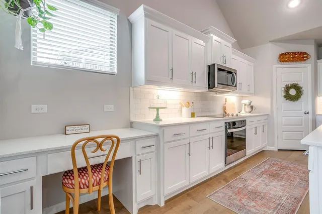 a kitchen with stainless steel appliances granite countertop a stove a sink and a microwave