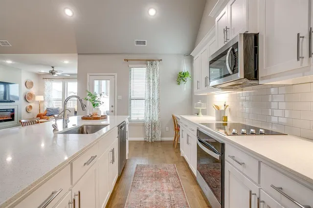 a kitchen with stainless steel appliances kitchen island granite countertop a sink stove and cabinets