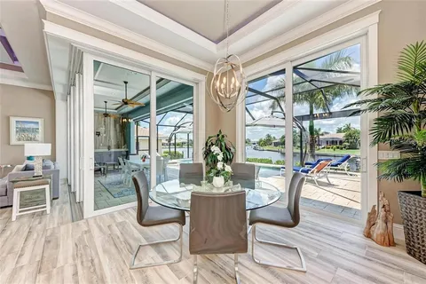 a dining room with wooden floor and glass windows