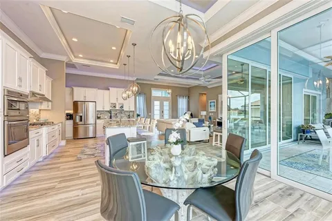 a view of a dining room with furniture a chandelier and wooden floor