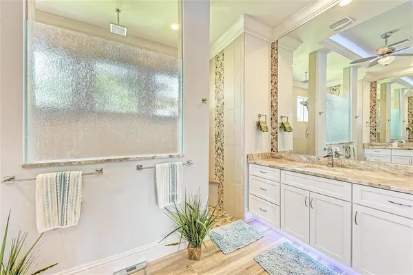 a bathroom with a granite countertop sink a toilet and a shower