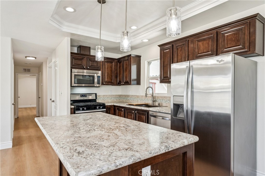 10550 Dunlap Crossing Road, Unit 141 Whittier, CA 90606 - Photo 9 of 38 a kitchen with granite countertop a refrigerator a stove and a sink