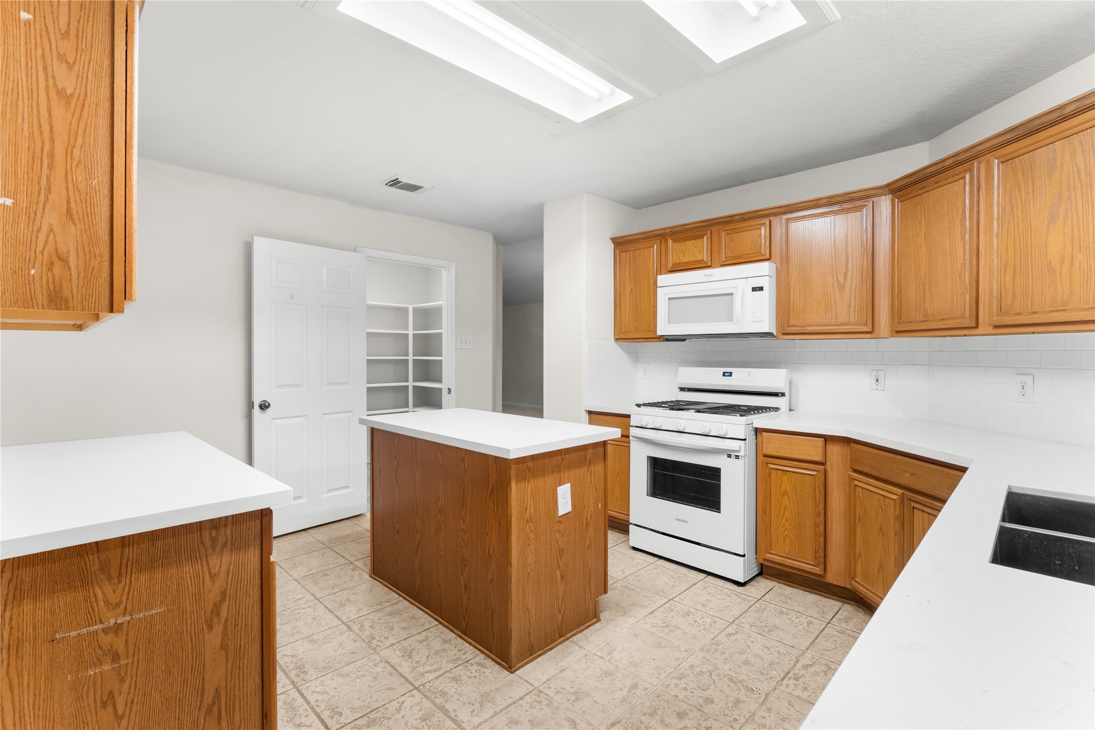 3522 Brackenfern Road Katy, TX 77449 - Photo 13 of 32 a kitchen with stainless steel appliances granite countertop a stove a sink and a microwave