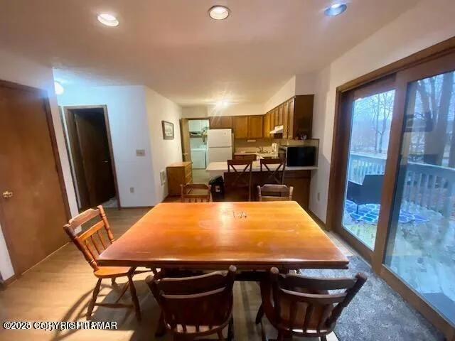 a room with stainless steel appliances dining table and a refrigerator