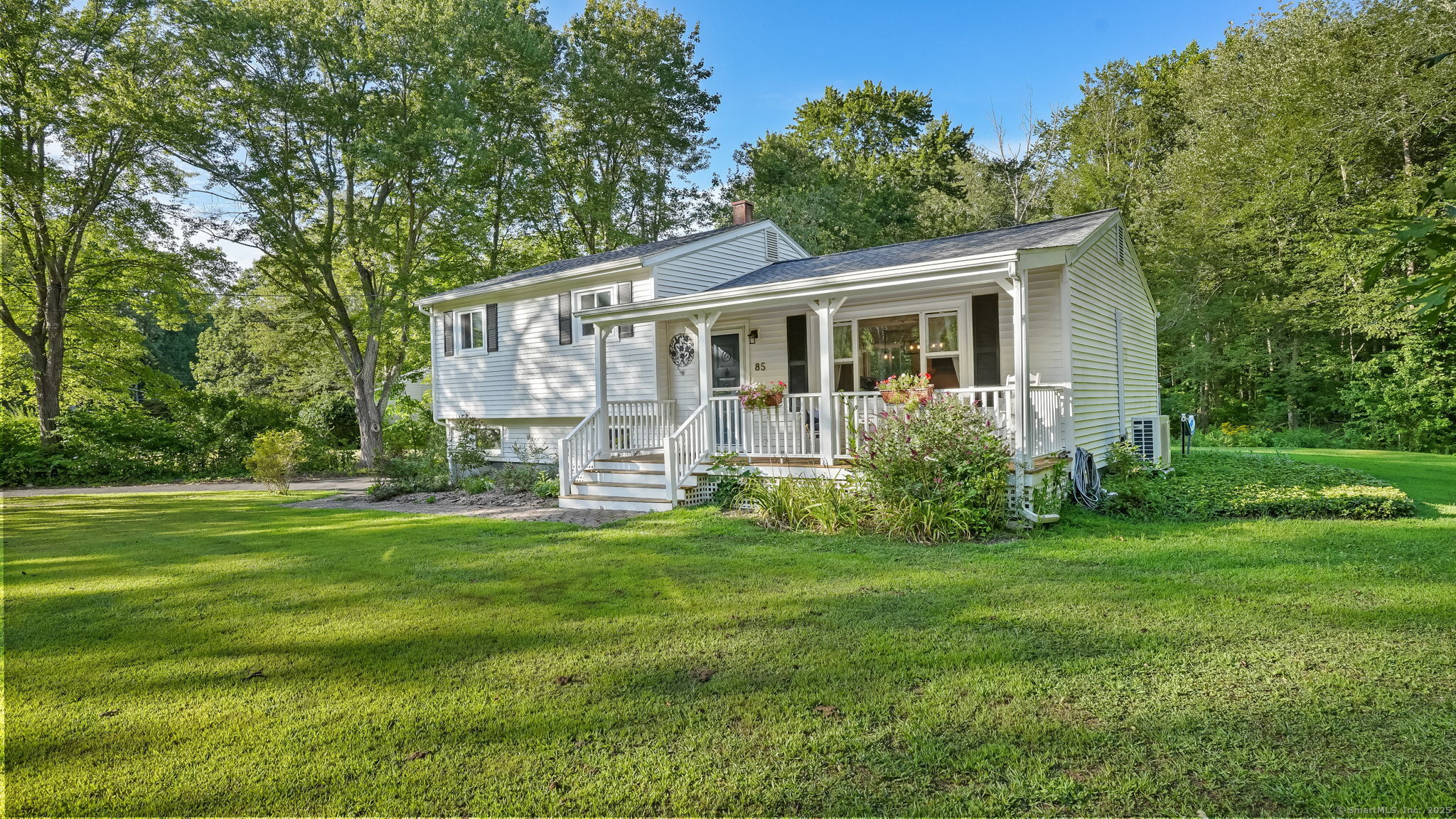 a view of a house with a big yard and large trees
