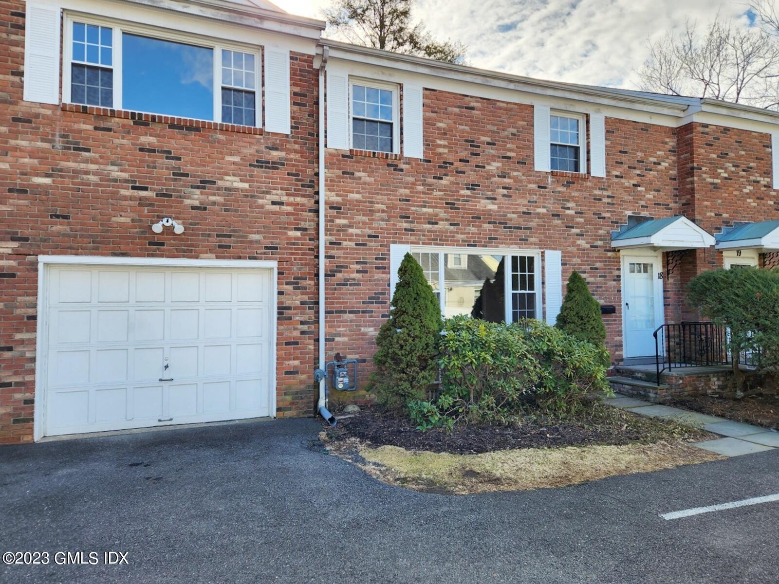 96 Valley Road, Unit 18 Cos Cob, CT 06807 - Photo 1 of 24 a view of a house with a yard and garage