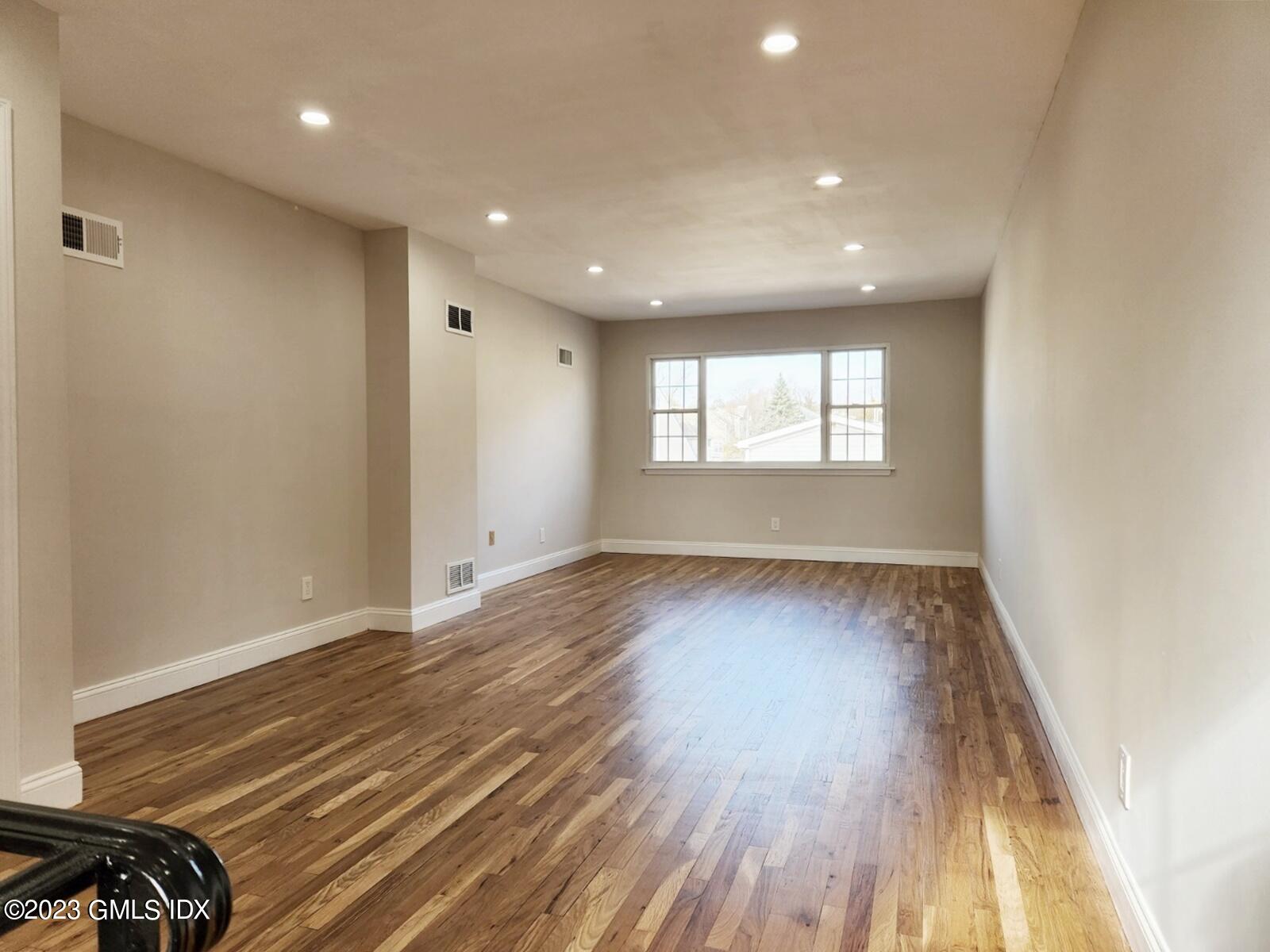 96 Valley Road, Unit 18 Cos Cob, CT 06807 - Photo 12 of 24 an empty room with wooden floor and windows
