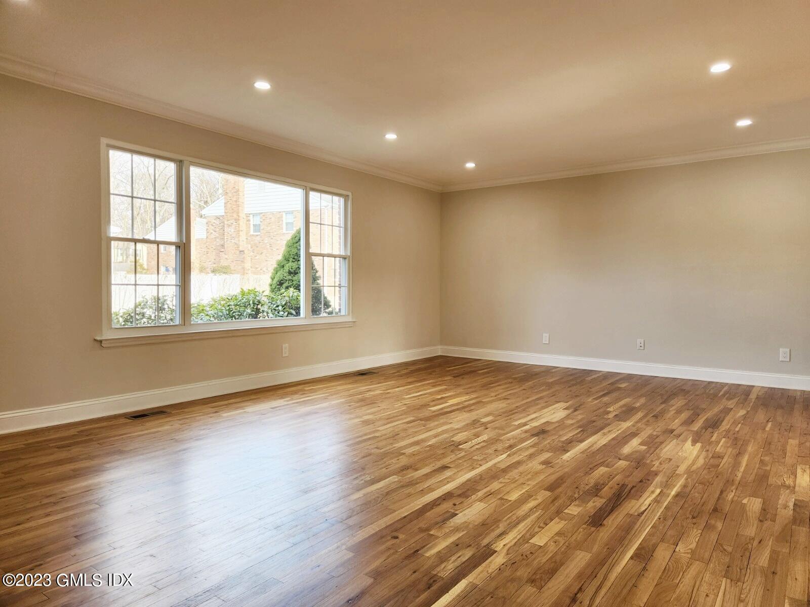 96 Valley Road, Unit 18 Cos Cob, CT 06807 - Photo 4 of 24 an empty room with wooden floor and windows