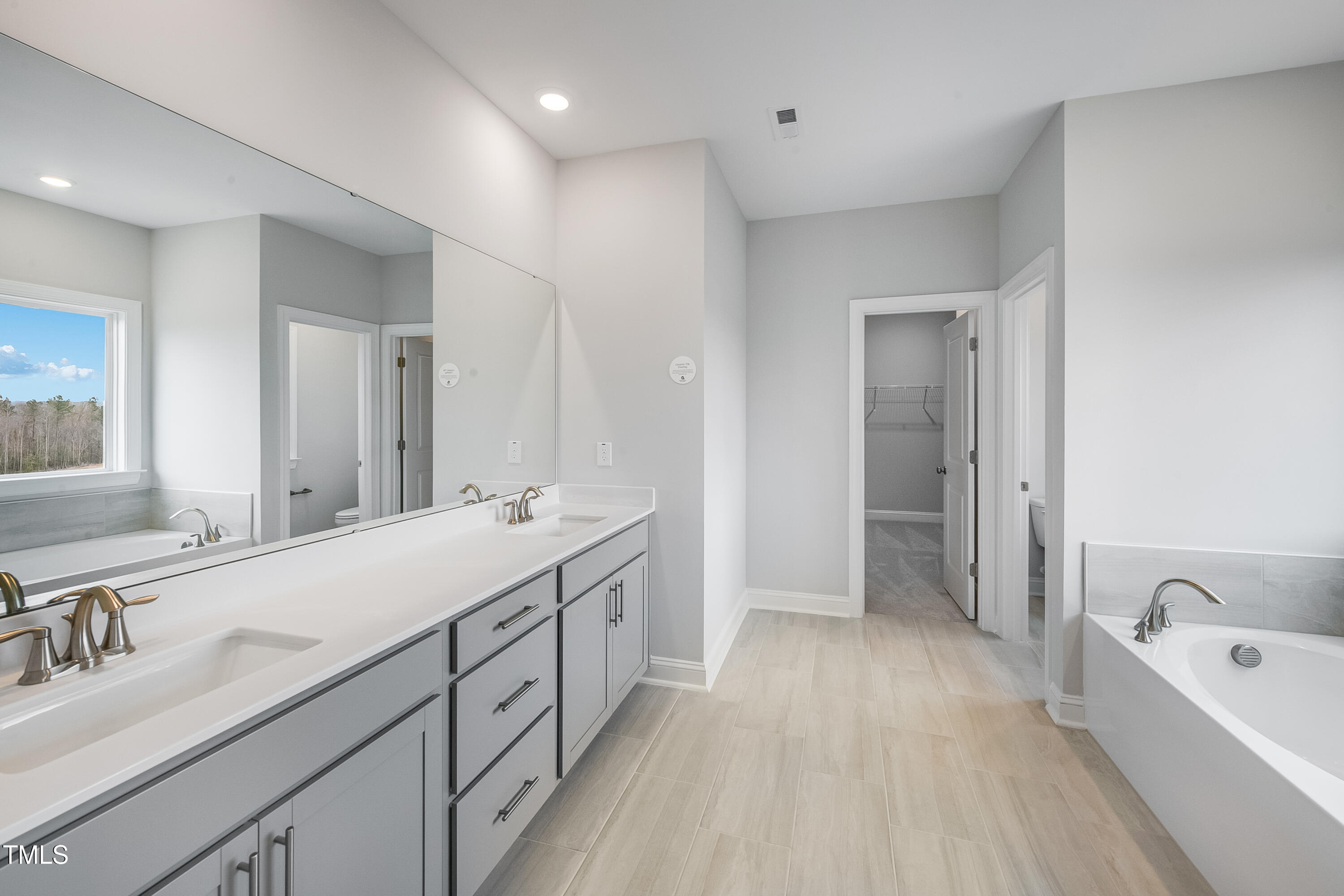150 East Stanton Street Garner, NC 27529 - Photo 13 of 18 a spacious bathroom with a double vanity sink a mirror and a bathtub