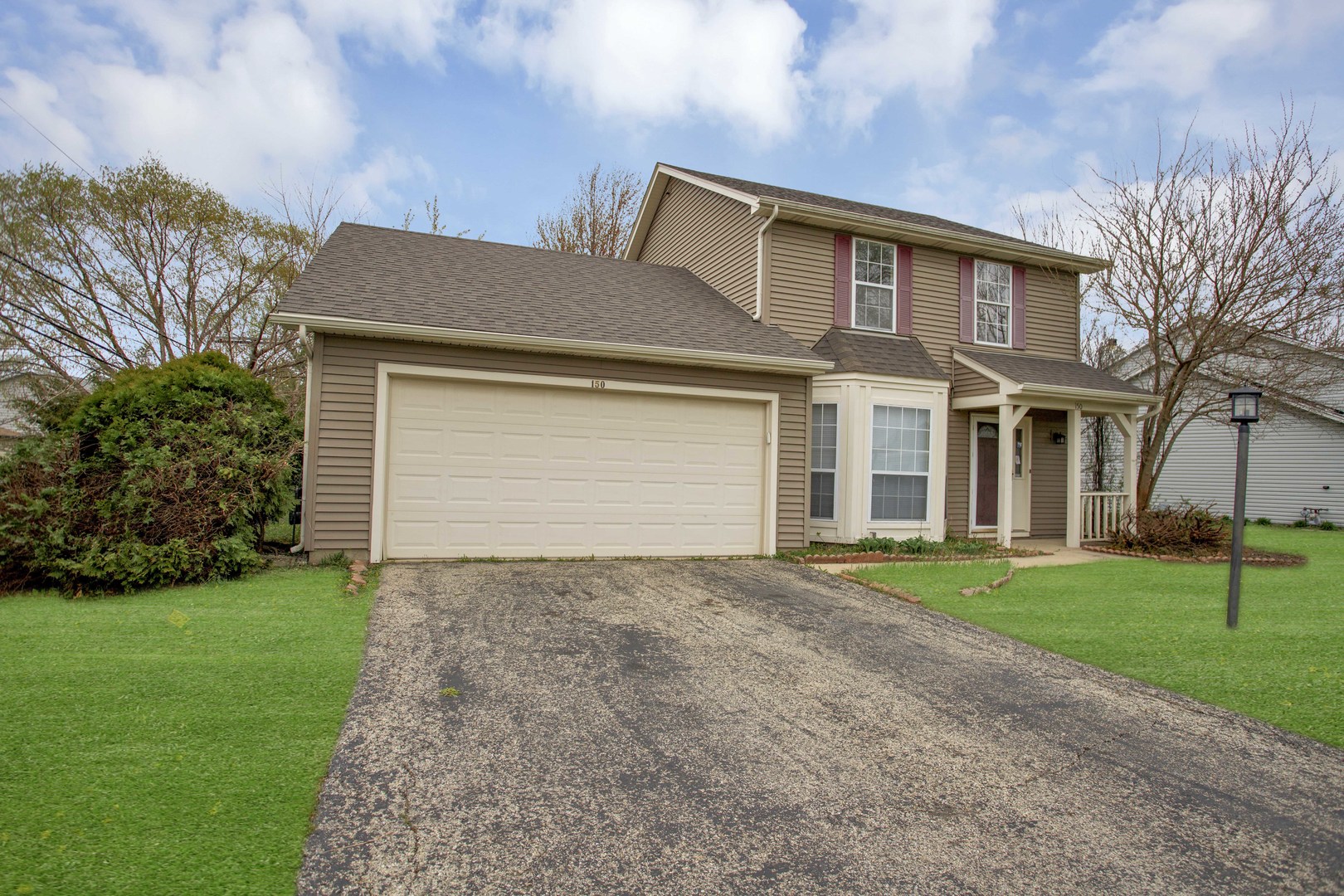 150 Seton Place Streamwood, IL 60107 - Photo 2 of 2 a front view of a house with a yard and garage