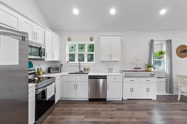 a kitchen with white cabinets and appliances