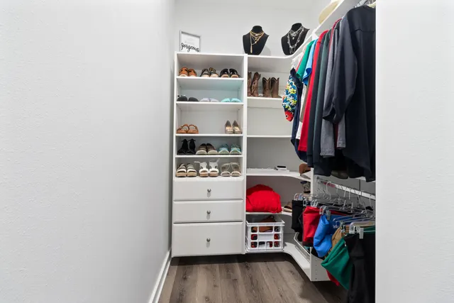 a view of walk in closet with clothes and shoes