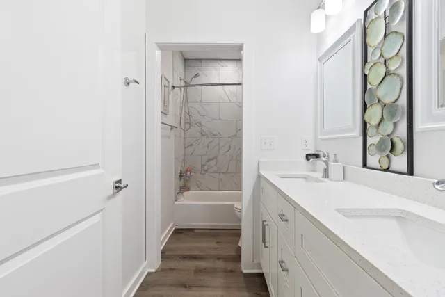 a bathroom with a granite countertop sink a toilet and shower