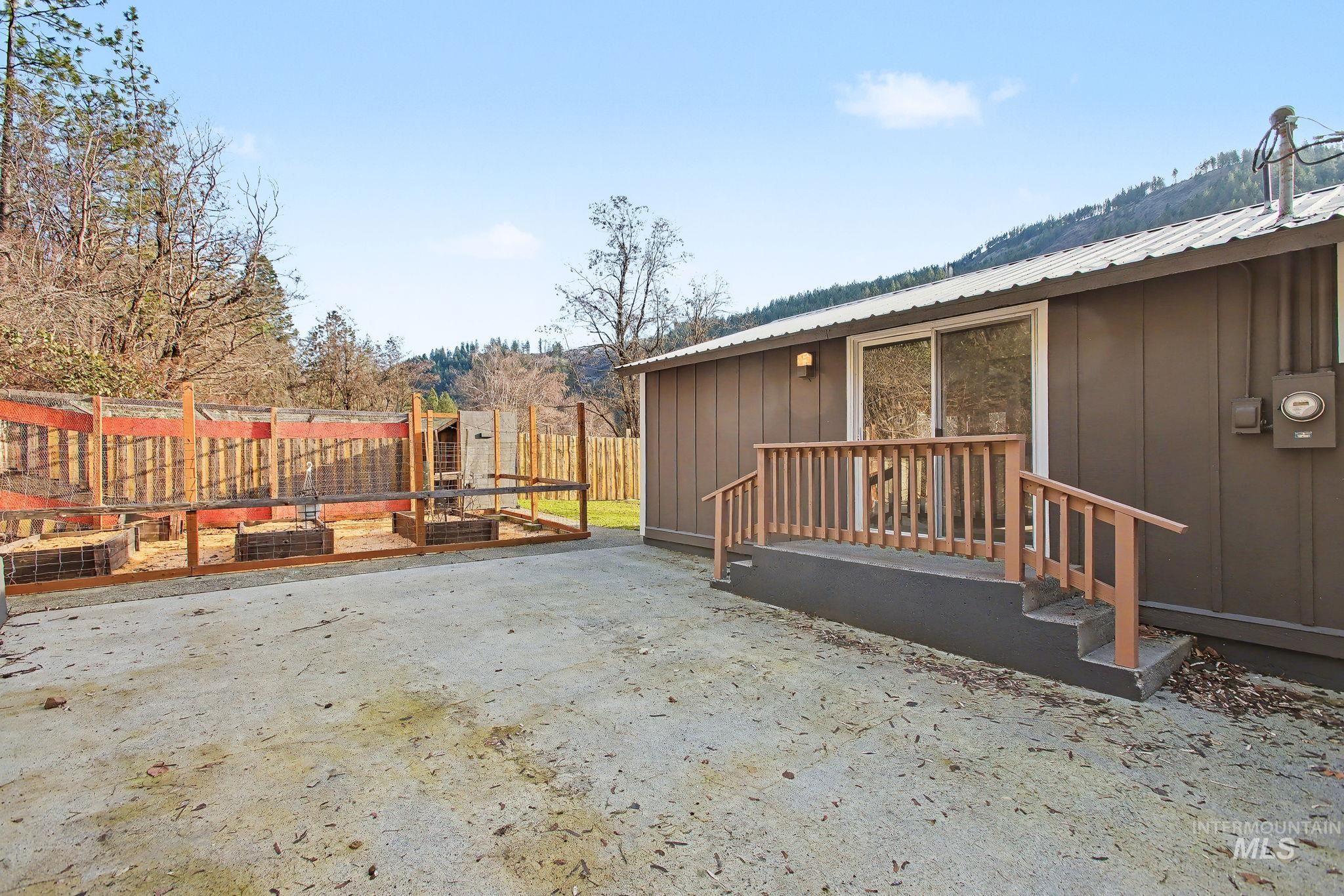 150 Elm Street Orofino, ID 83544 - Photo 29 of 36 Rear exterior featuring a sliding glass door, wooden deck with railings, board and batten siding, and a metal roof