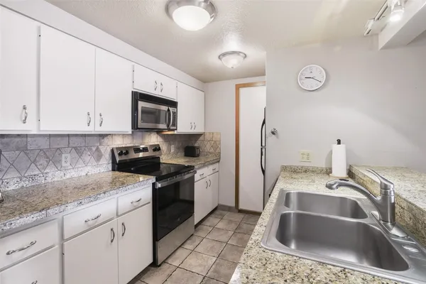 a kitchen that has a sink and a stove top oven