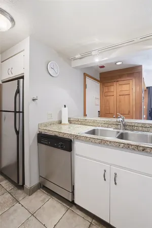 a kitchen with stainless steel appliances granite countertop a sink and a refrigerator
