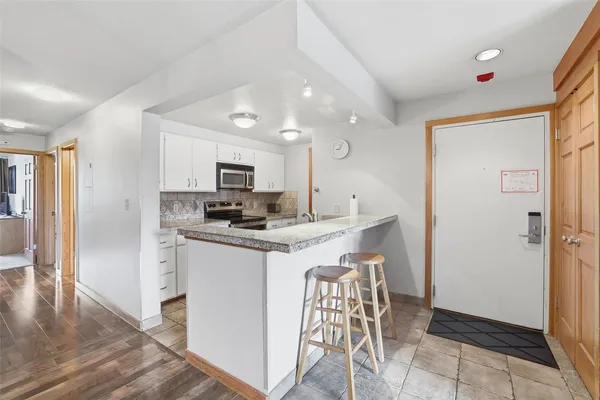 a kitchen with stainless steel appliances granite countertop a refrigerator and a stove top oven