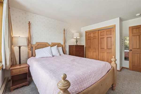 a bedroom with a bed and a refrigerator