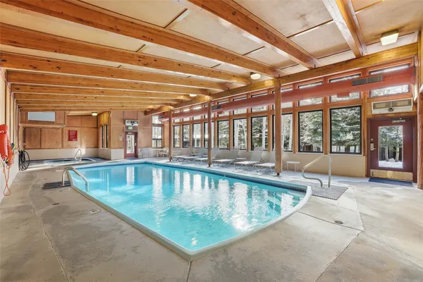 a view of indoor pool and dining table and chairs under an umbrella