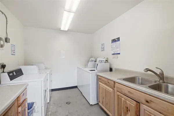 a utility room with sink dryer and washer