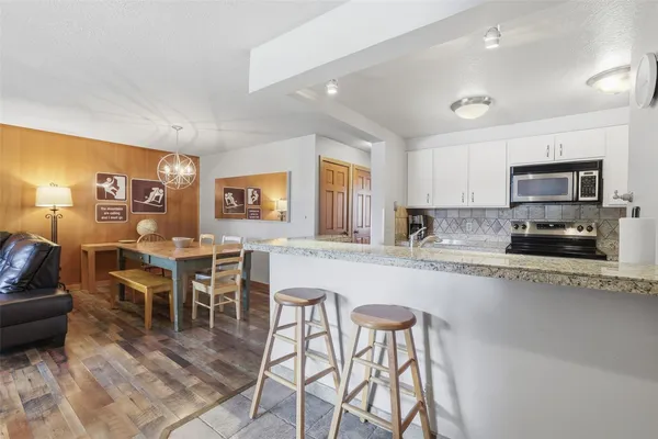 a large kitchen with cabinets table and chairs