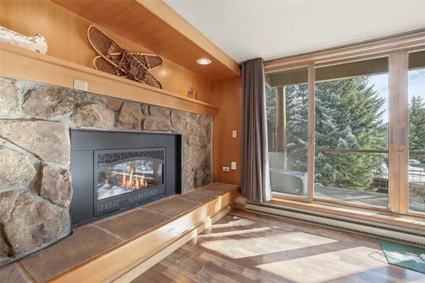 a living room with a fireplace and a floor to ceiling window