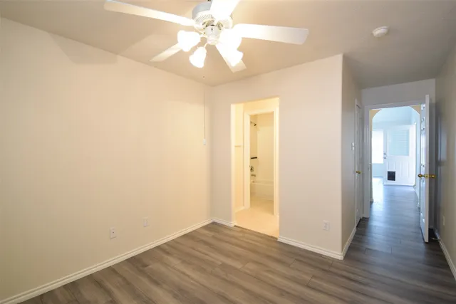 a view of a big room with wooden floor and a ceiling fan