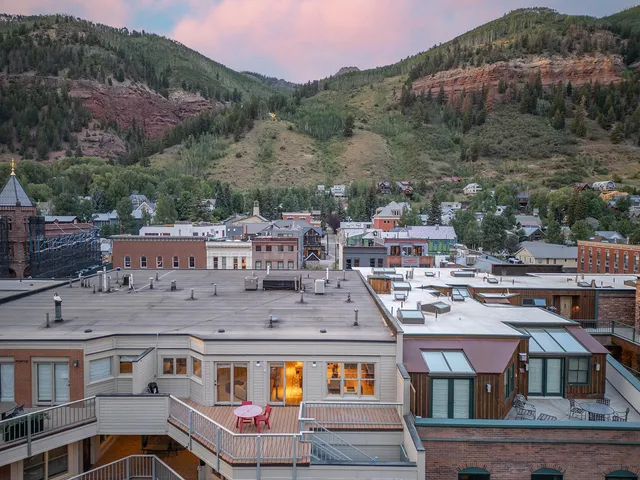 an outdoor sitting area with furniture and city view