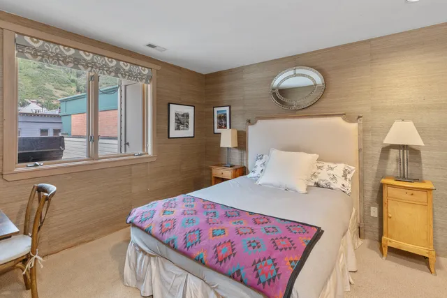 a bedroom with furniture and a large window